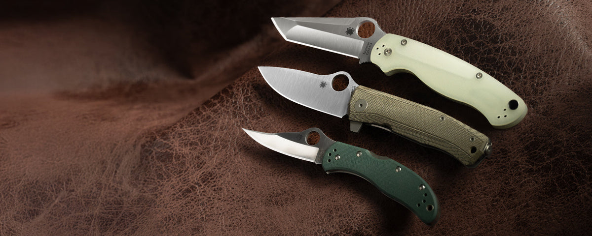 A picture of 3 knives resting on leather material.