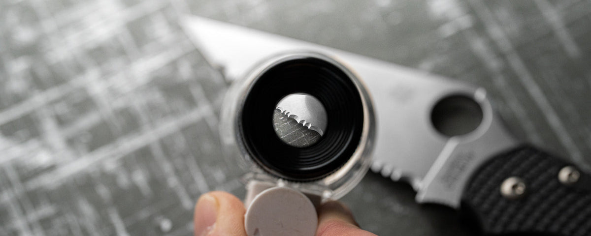 Looking through a loupe at the edge of a serrated blade.