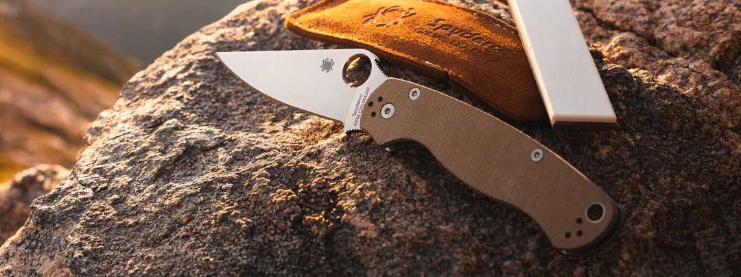 A Para Military 2 folding knife placed on a rock.
