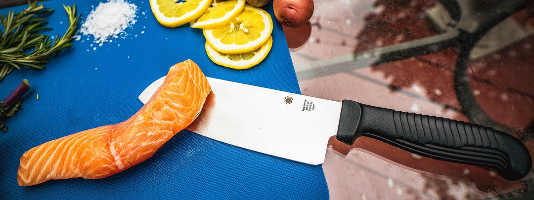 Image of a Spyderco Santoku being used to cook outdoors.