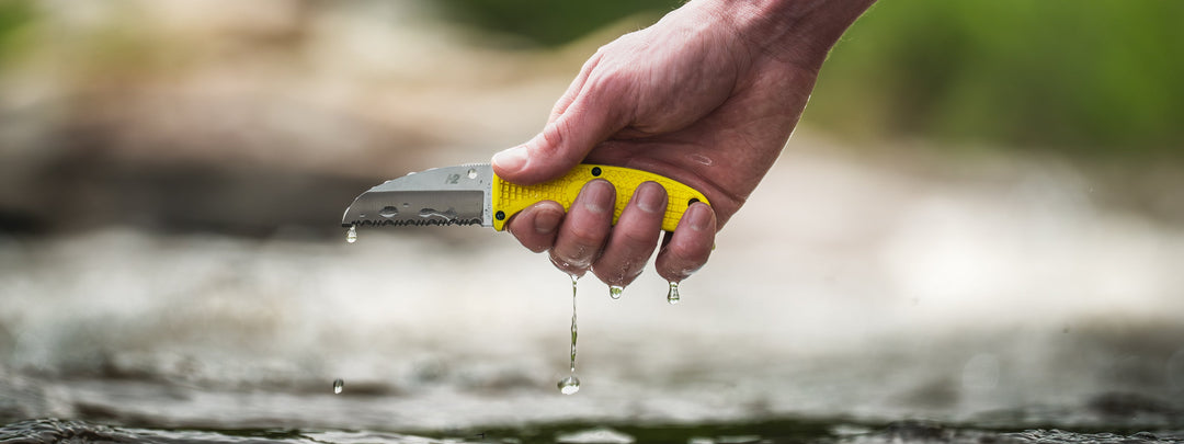 An image of a Spyderco Salt Series fixed blade being rinsed in a stream.  Enuff Salt.