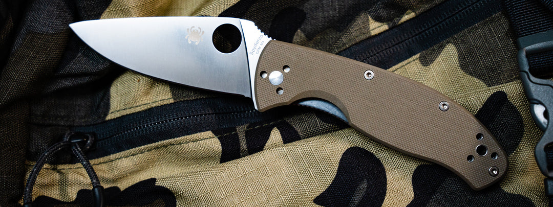 An image of a Spyderco value folder open on a camouflage background.  Tenacious. 