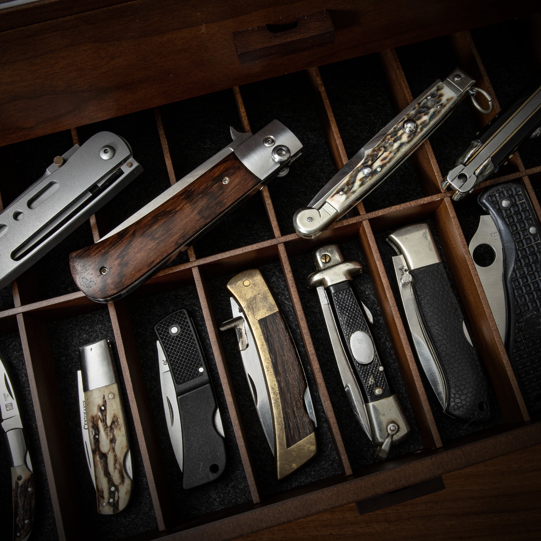 A collection of back lock knives in a display case.