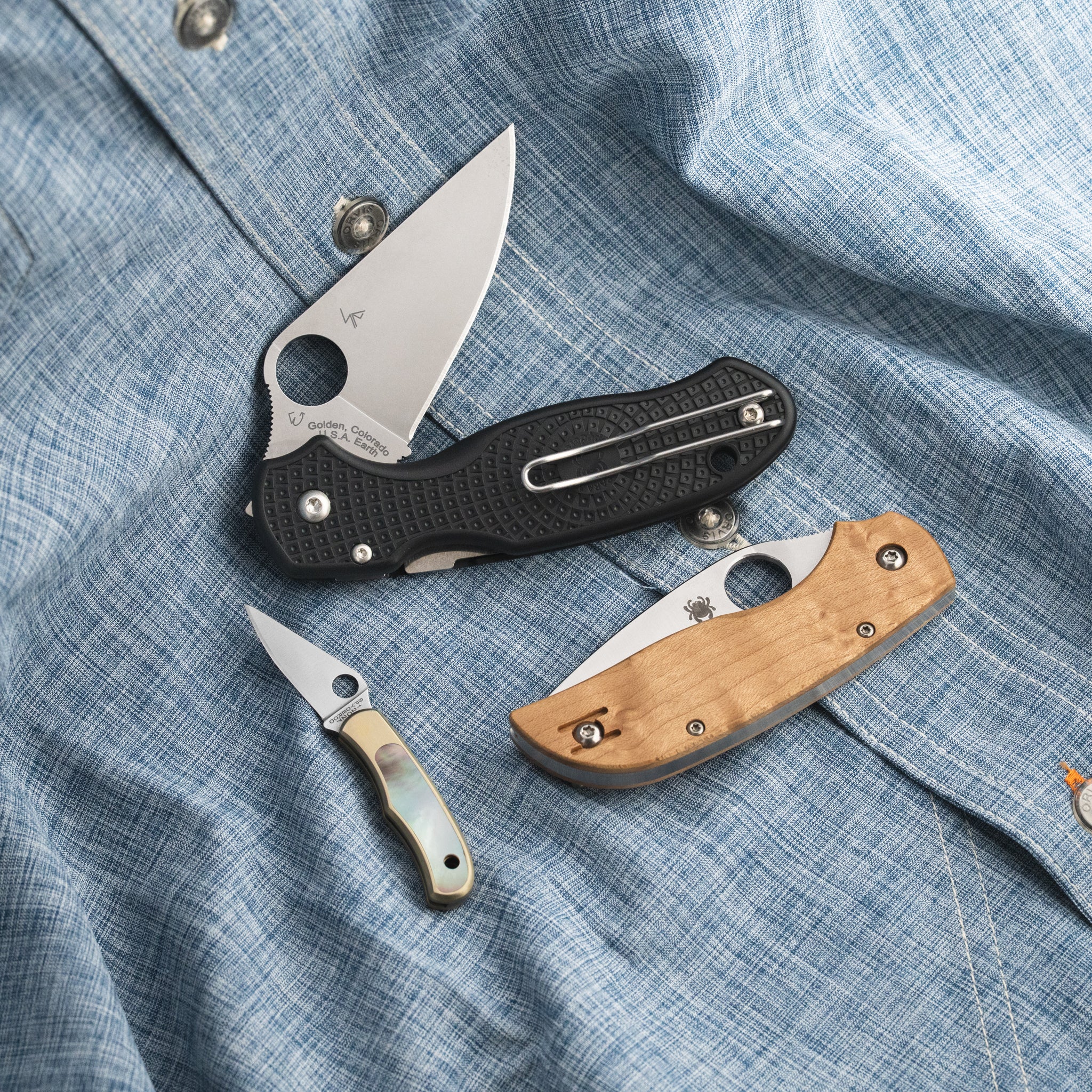3 knives on a blue button up shirt.